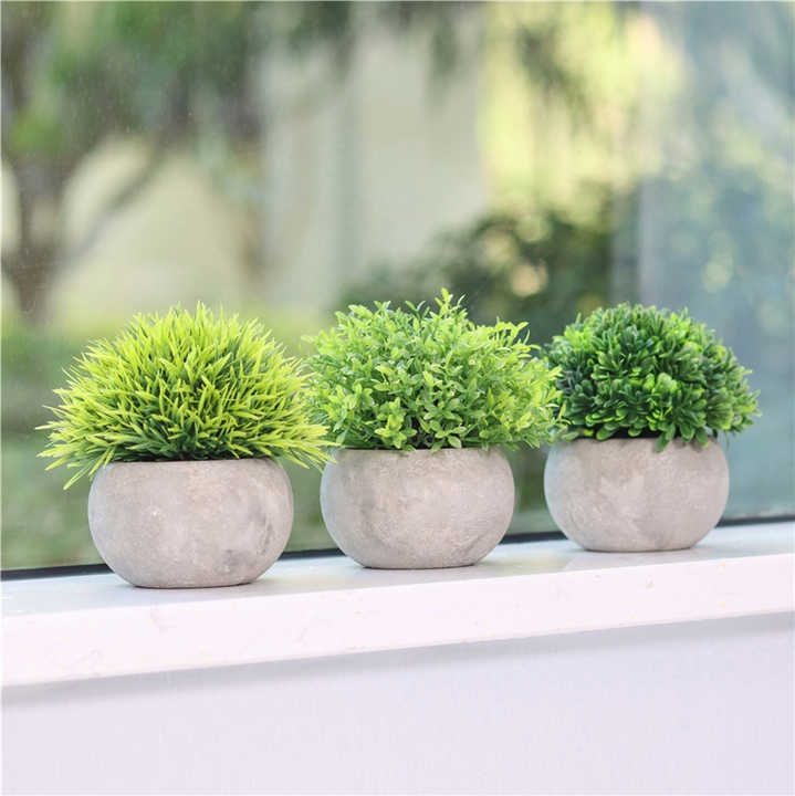 Small artificial plants in plastic pots. 