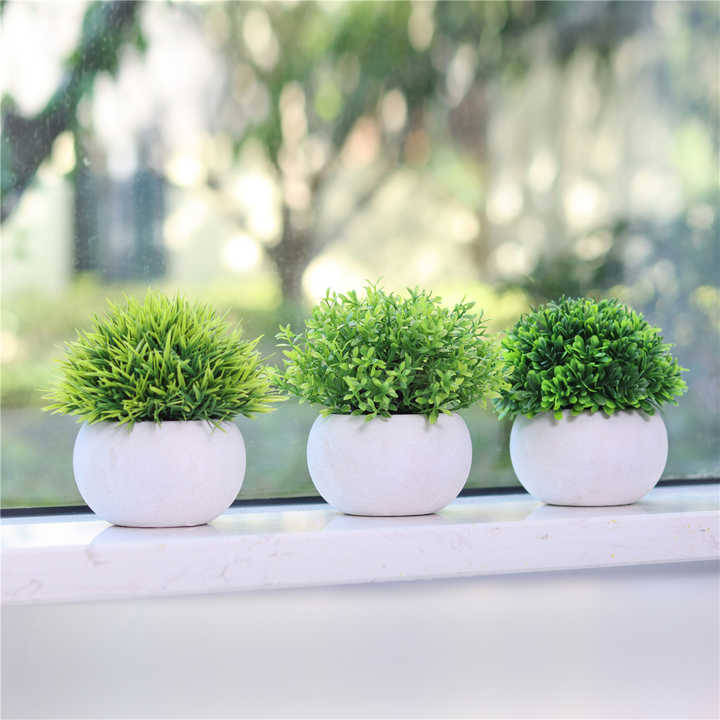Small artificial plants in plastic pots. 