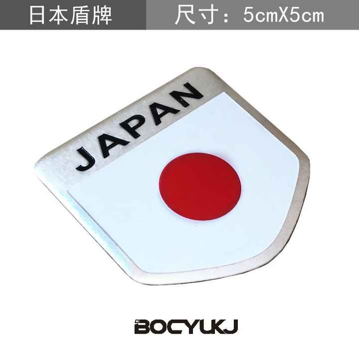 Metal badge bearing the Japanese flag emblem. 