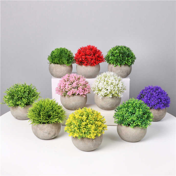Small artificial plants in plastic pots. 
